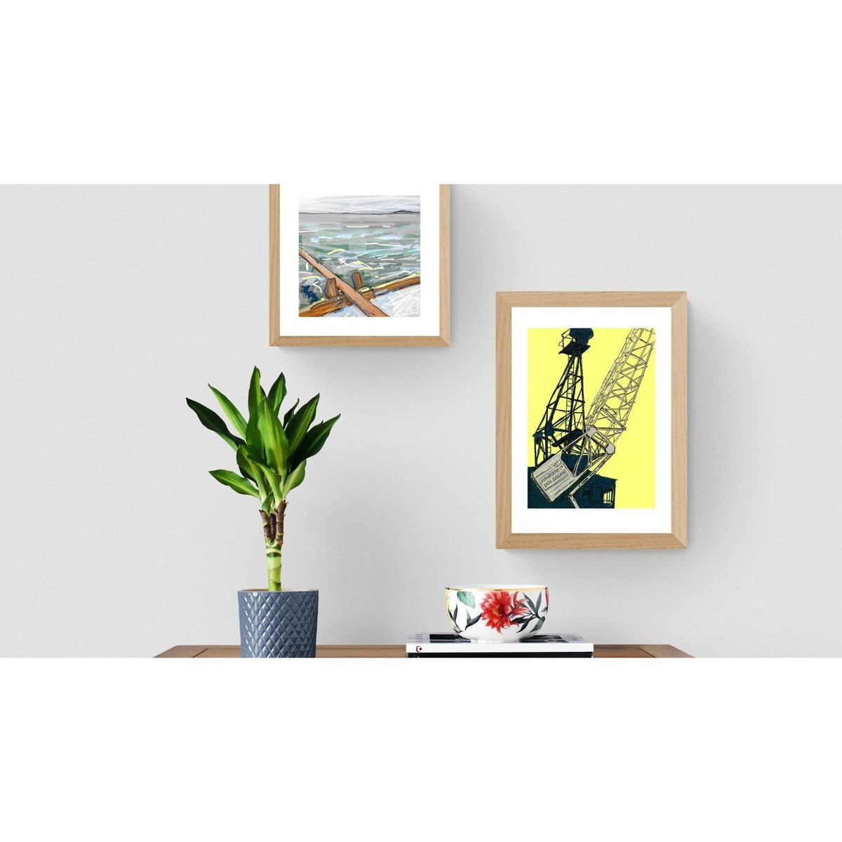 rowing boat and crane prints on grey wall with plant and chest of drawers