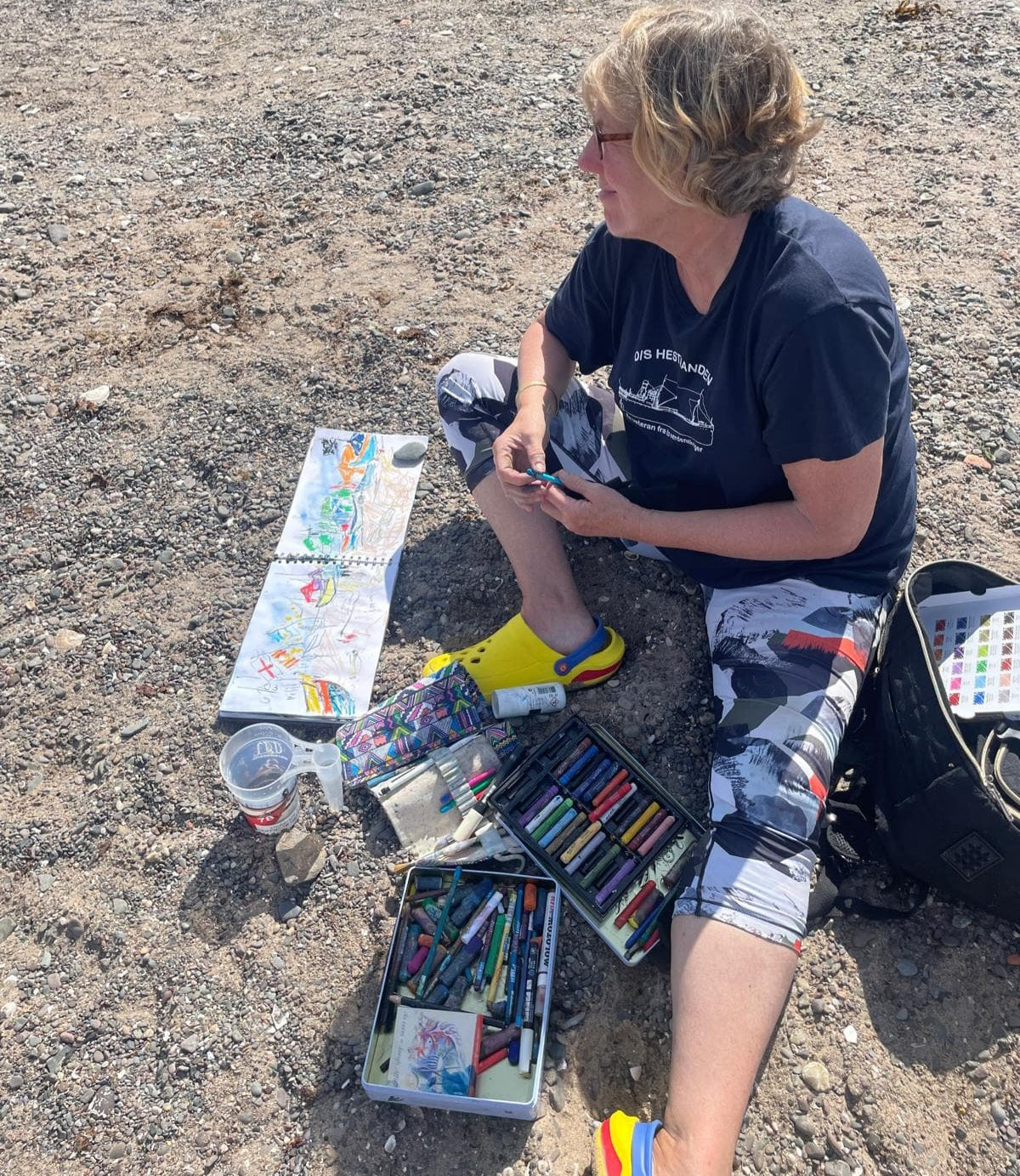 Artist sitting on beach sketching